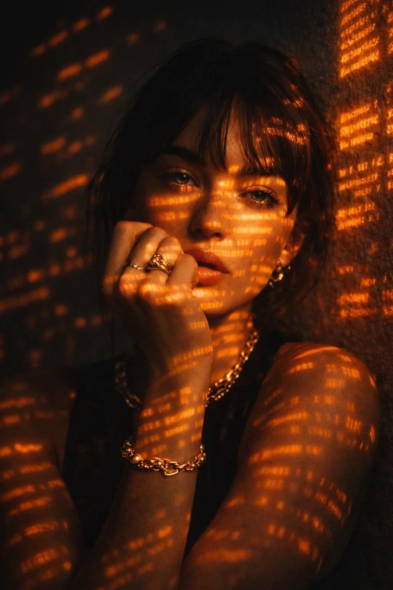 Make a cinematic low-key portrait of a women with dark hair, leaning slightly against a textured wall, looking directly at the camera with