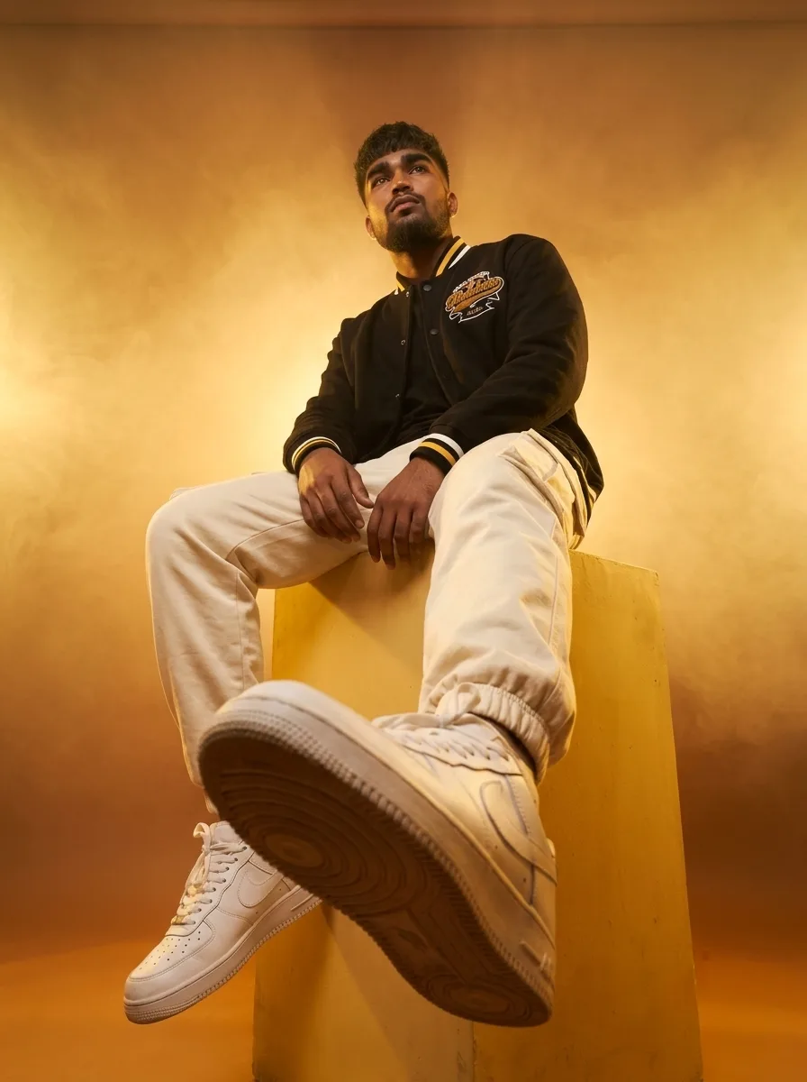 Detailed AI Image Prompt Vertical dynamic worm's-eye perspective fashion portrait of a young man sitting on a yellow geometric block