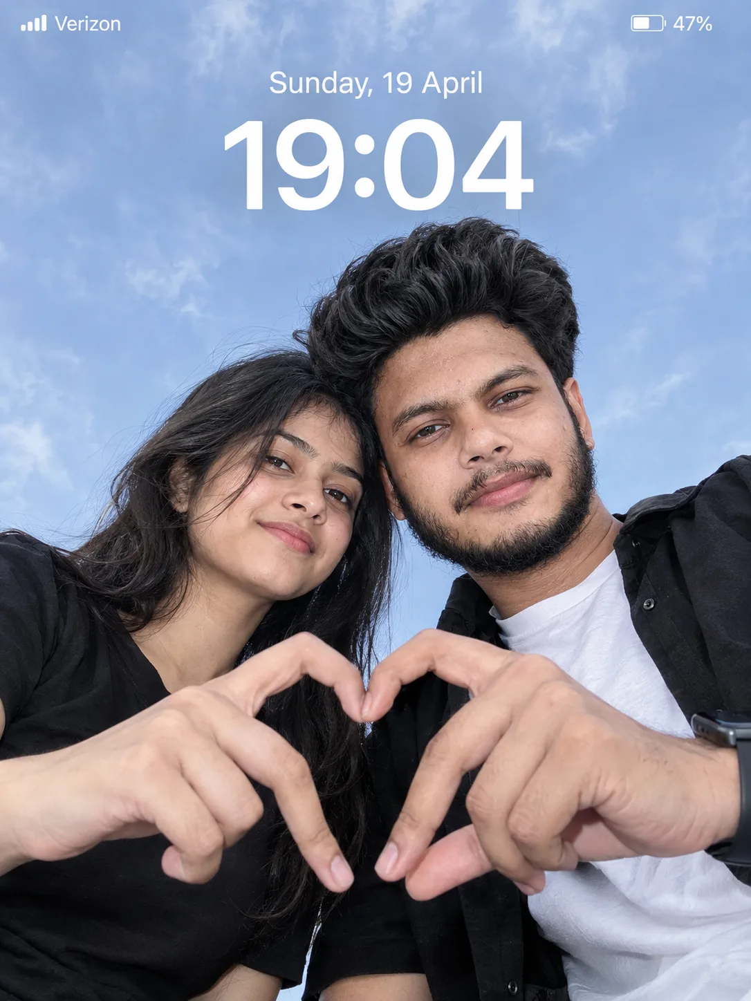 Create an ultra-realistic cinematic low-angle couple portrait with a smartphone lockscreen UI overlay.