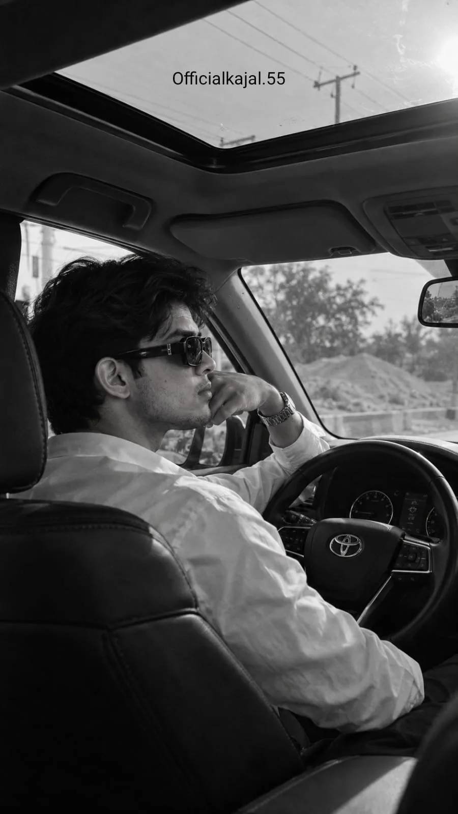 @officialkajal.55 Black and white monochrome cinematic photograph, interior view of a car shot from the rear passenger seat over the