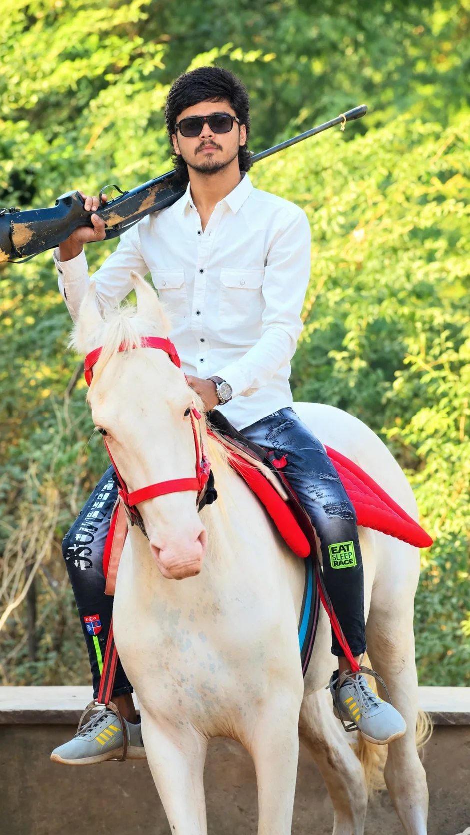 Create an ultra-realistic, photorealistic vertical outdoor portrait of a young South Asian/Indian man confidently riding a majestic white