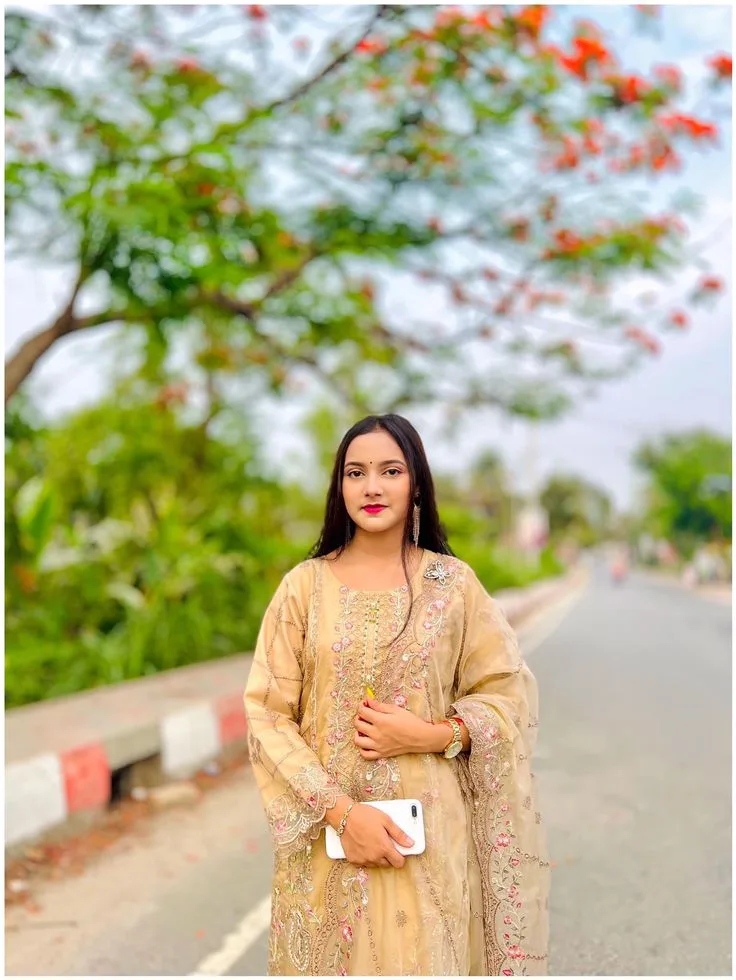 A photorealistic vertical medium shot in exact 3:4 aspect ratio capturing the young South Asian woman from the reference image standing