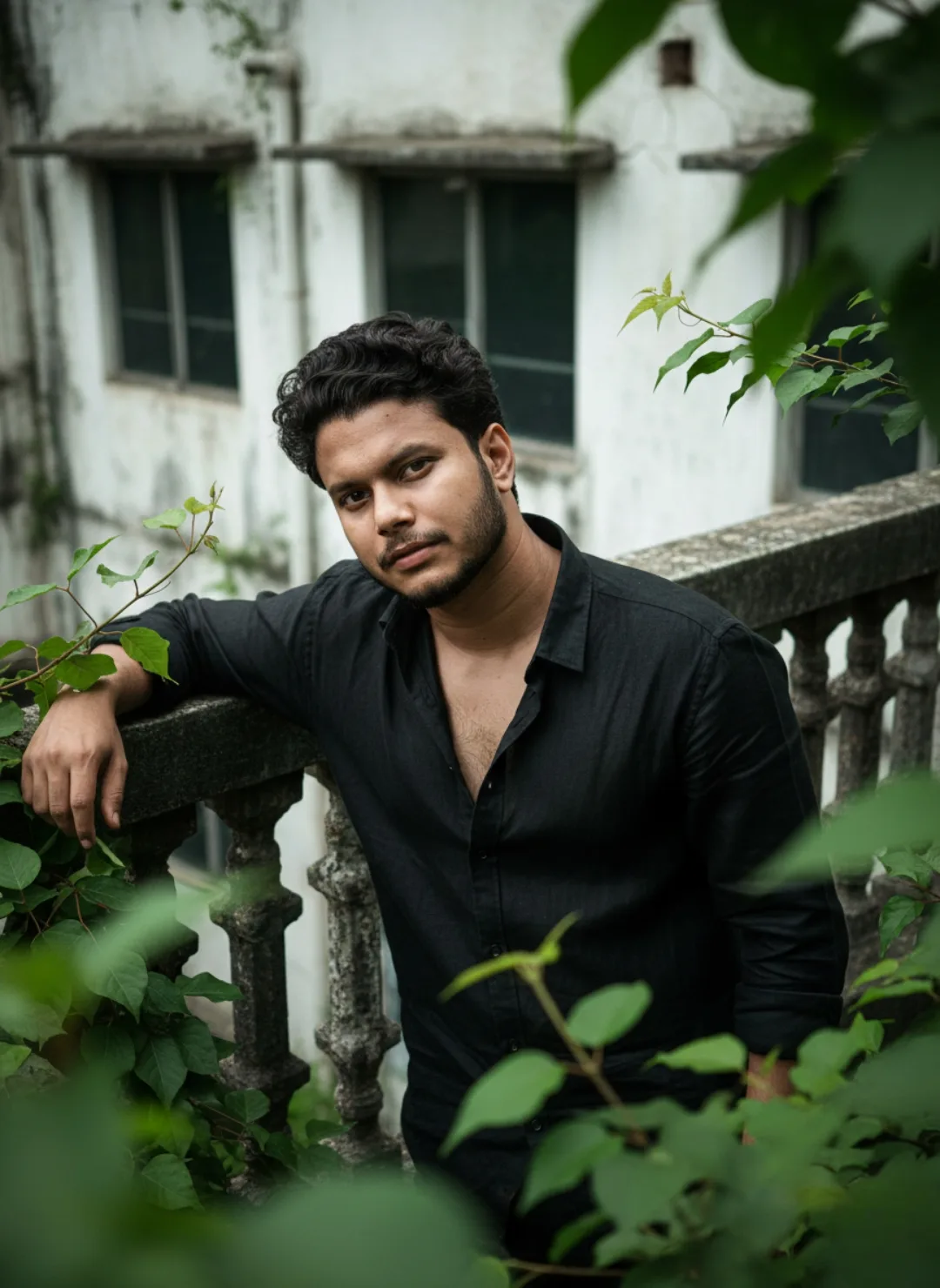 A realistic medium shot portrait of a 26-year-old South Asian man with a well-groomed beard, short wavy black hair, and an expressive gaze,