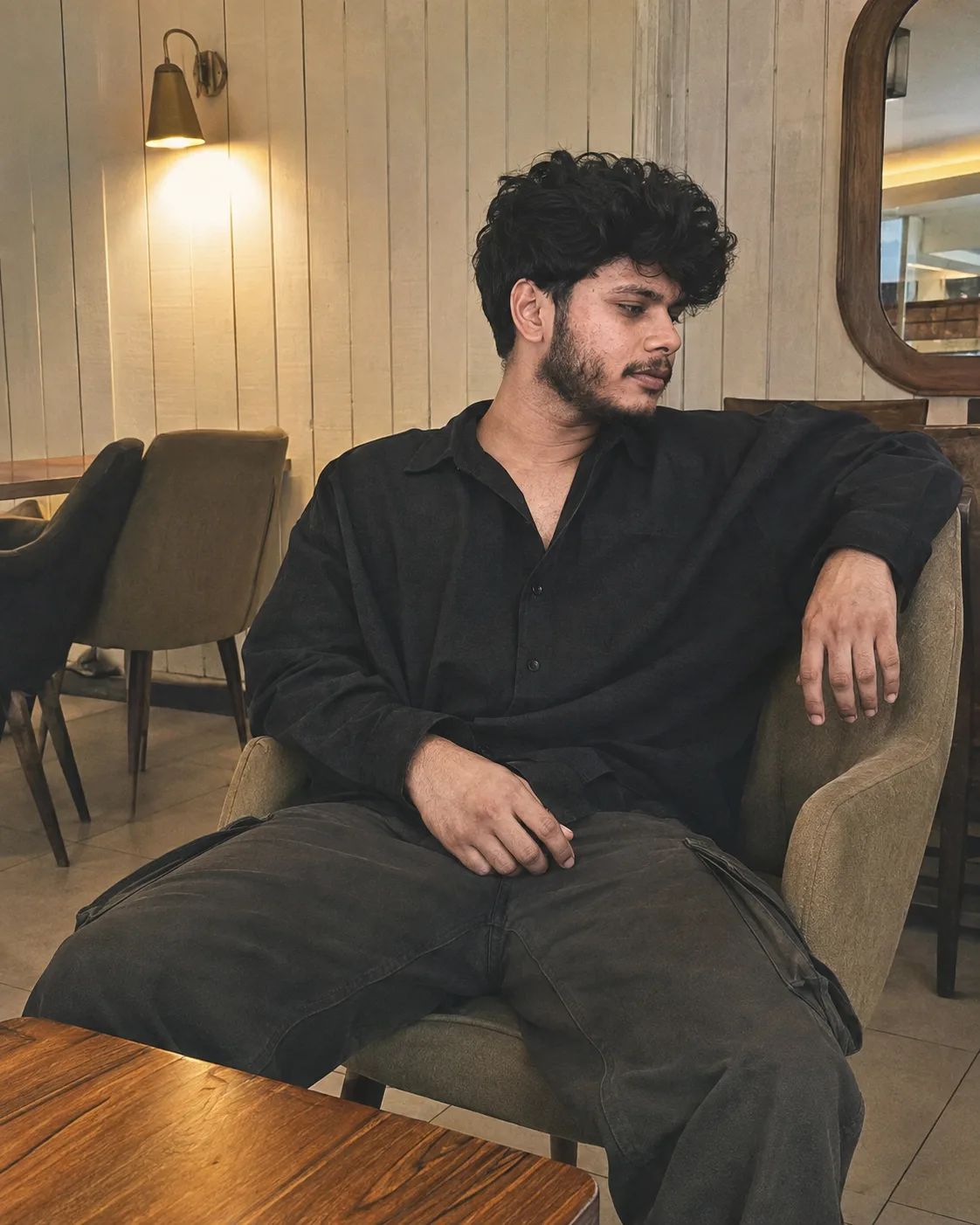 A cinematic, high-resolution lifestyle photograph of the same 26-year-old male subject from the reference image, maintaining strict facial
