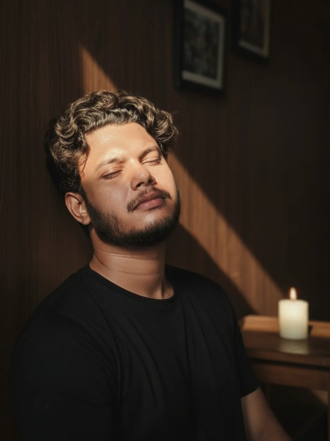 AI Image Prompt: > A realistic, cinematic medium close-up portrait of a 26-year-old Indian man with curly hair, closed eyes, and a relaxed,
