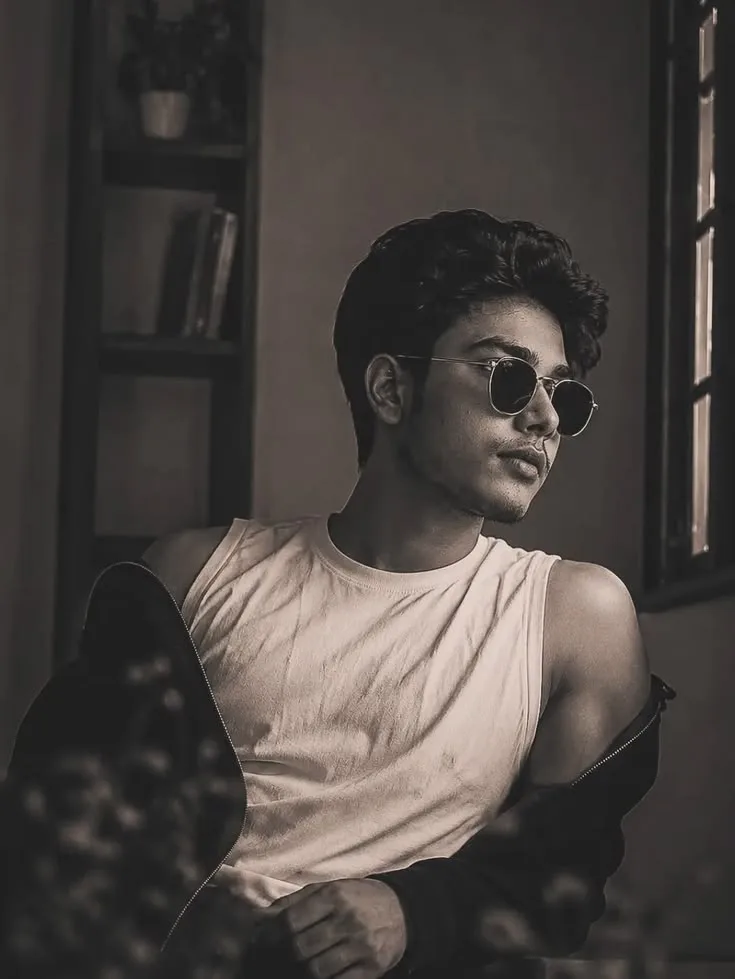 A photorealistic vertical portrait of the young South Asian man from the reference images, faithfully preserving his exact facial identity,