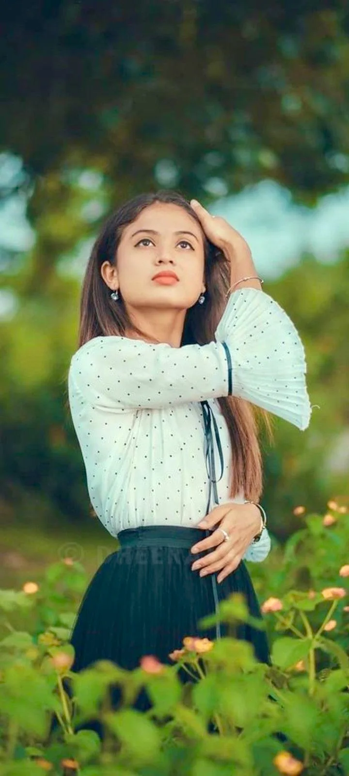 A photorealistic vertical medium shot of the young South Asian woman from the reference image, faithfully preserving her recognizable