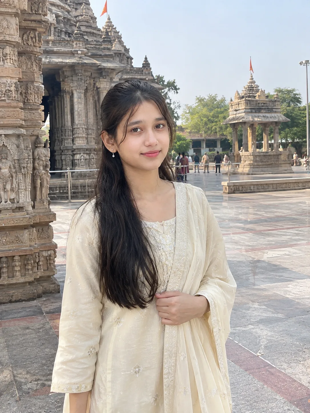 Ultra realistic photograph of a young woman standing in a temple courtyard during daytime, shot on a real DSLR camera.