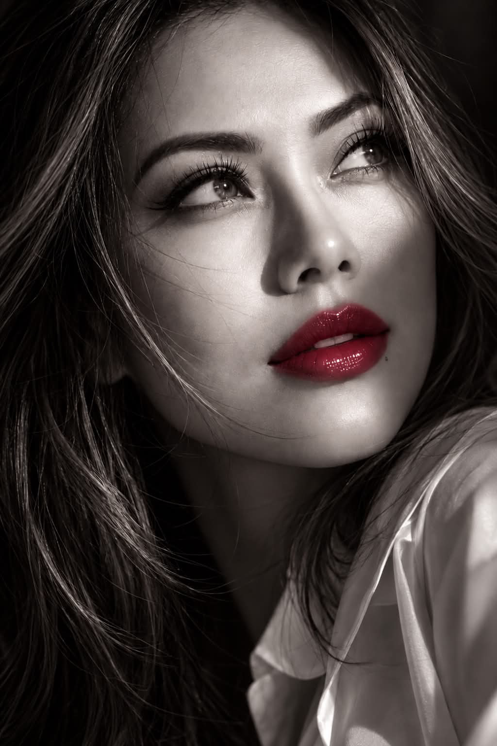 Ultra-photorealistic cinematic close-up portrait of an elegant young woman, face filling most of the frame, head slightly tilted upward,
