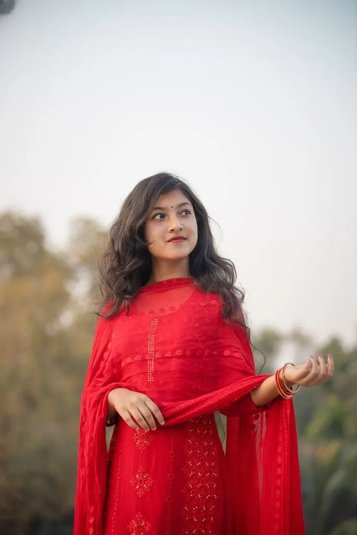 A photorealistic vertical portrait of the young South Asian woman from the reference image, faithfully preserving her exact facial