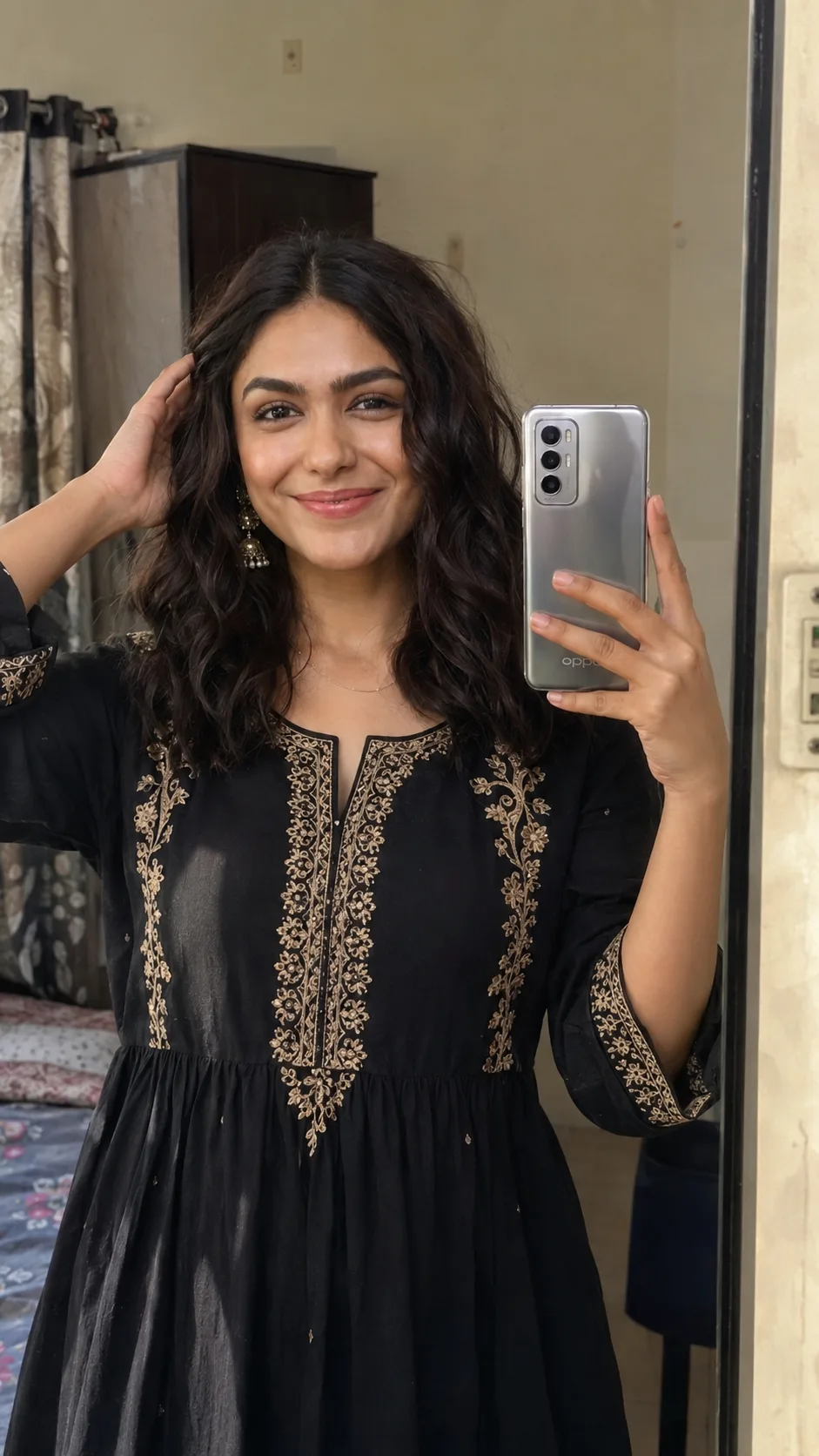 Ultra-realistic 9:16 vertical mirror-selfie, mid-shot (head-to-waist) of a young Indian woman in a simple middle-class room.
