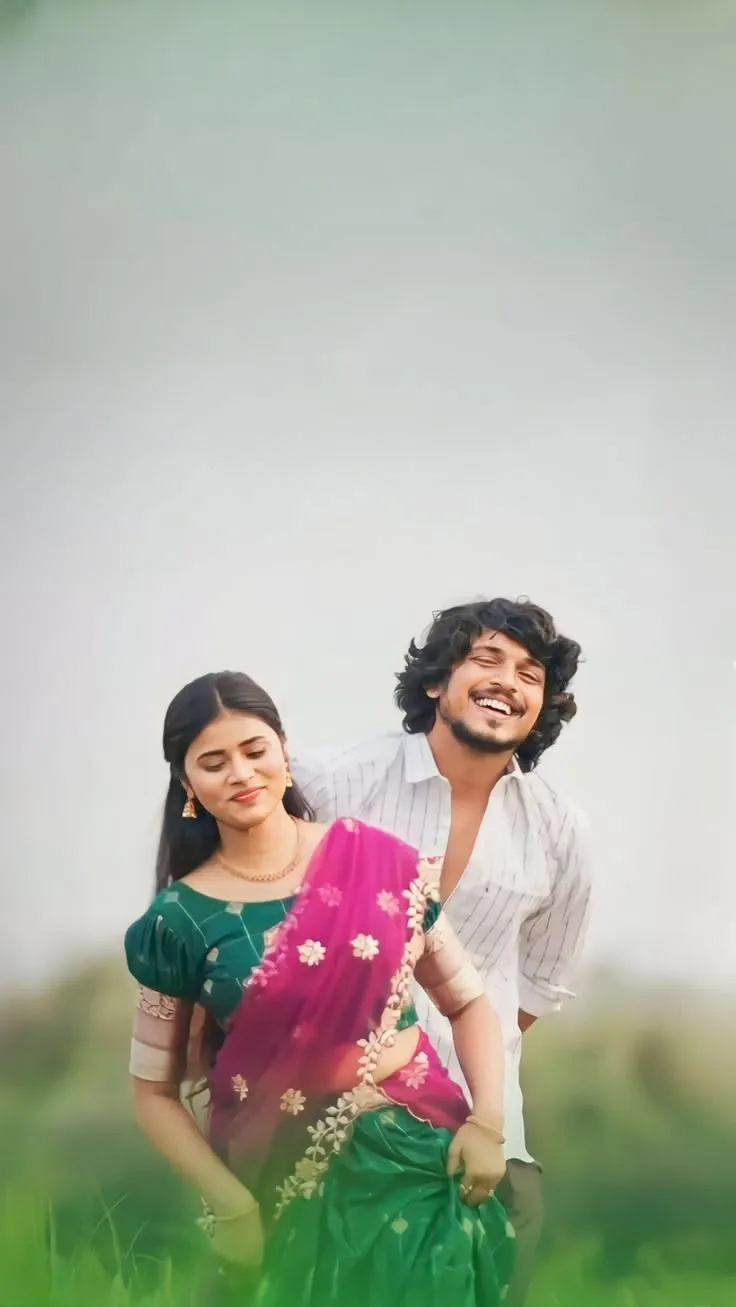 A photorealistic vertical medium shot of the young South Asian couple from the reference image, faithfully preserving both subjects' exact