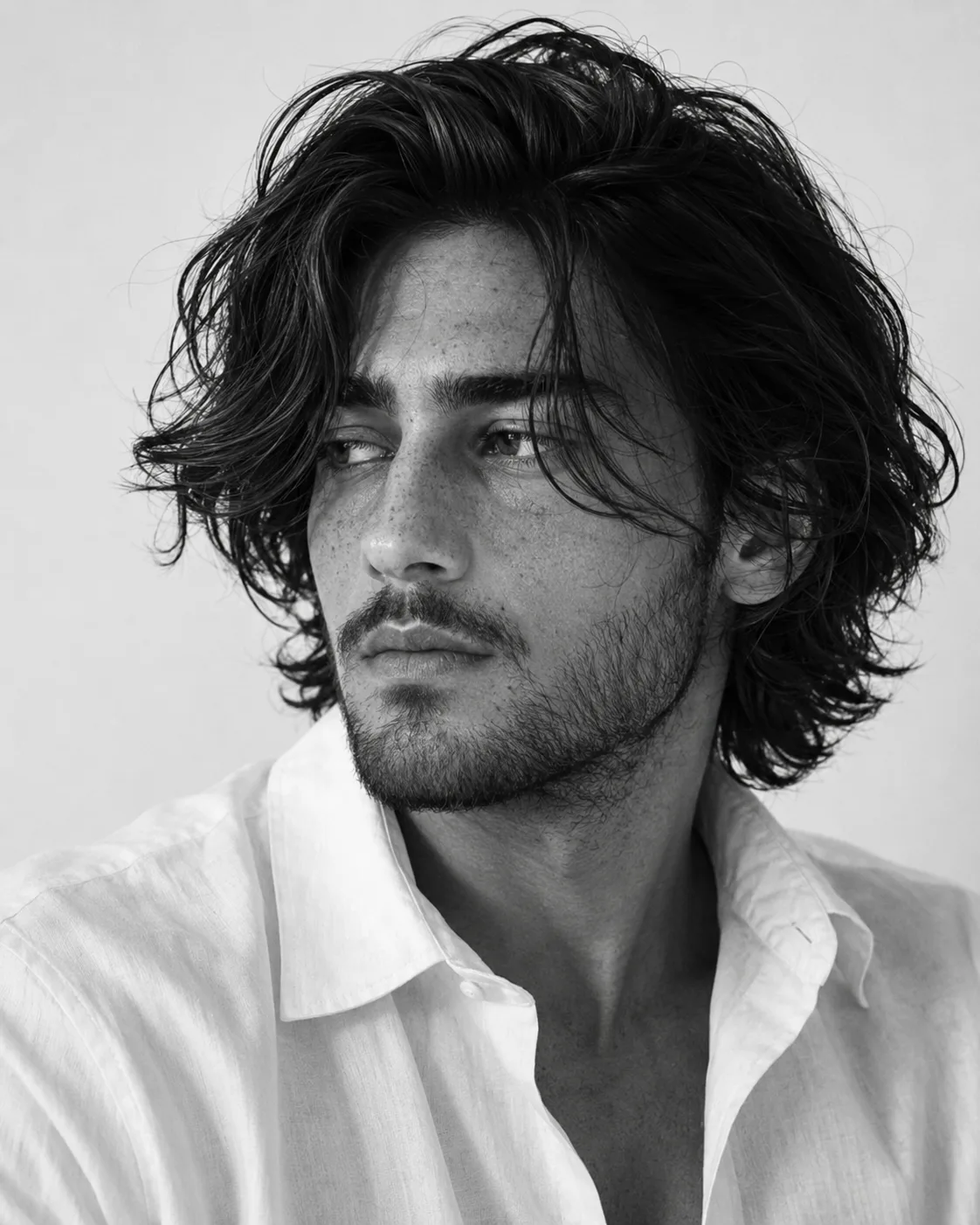 A highly detailed, photorealistic **black-and-white editorial portrait of a handsome young adult man**, captured in a tight close-up from