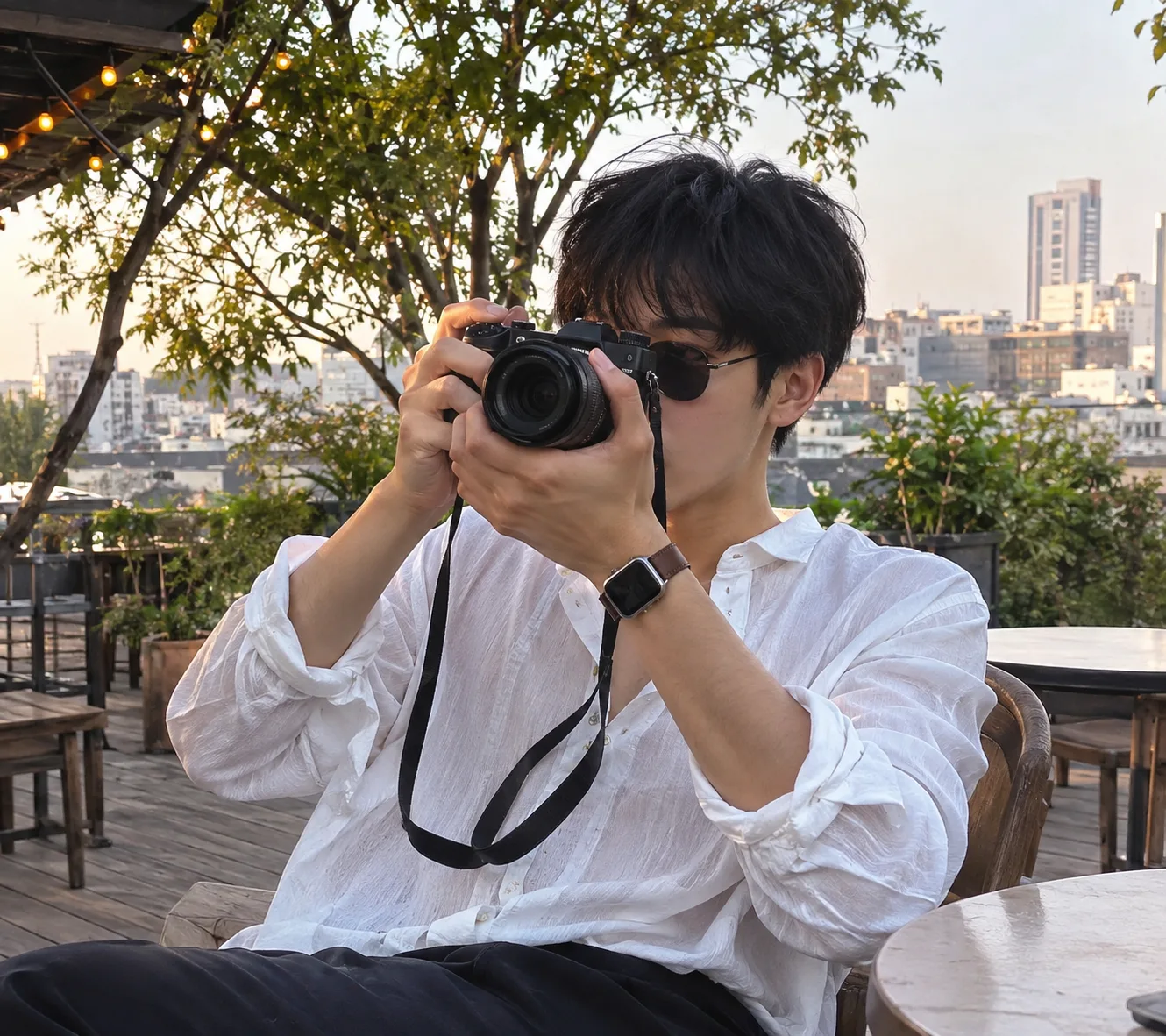 Create an ultra-realistic, premium editorial lifestyle photograph of a stylish young male photographer sitting casually at an elegant