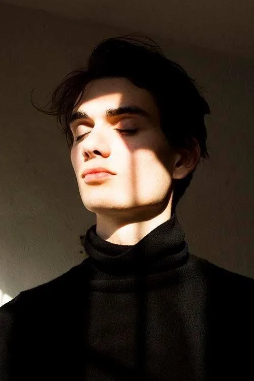 A hyper-realistic cinematic portrait of a young attractive man with messy dark hair, eyes closed peacefully, serene expression, tilted head
