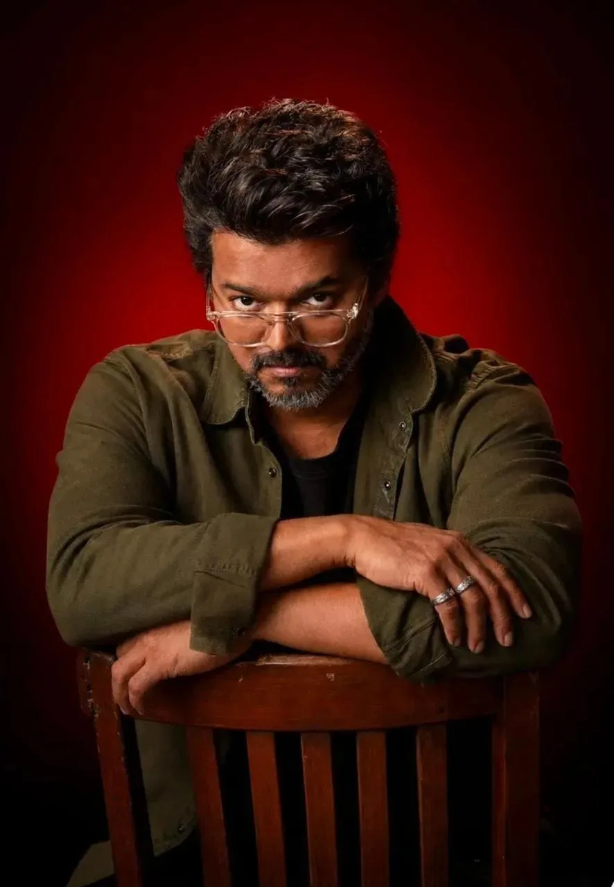 Vertical 4:5 low-key studio photograph on a field that burns red behind him and falls to black at the frame edges — a red-to-black gradient