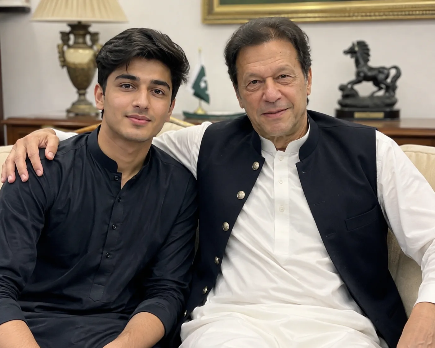 Create an ultra-realistic, high-end photographic portrait of a young South Asian boy sitting naturally beside **Imran Khan**, both looking