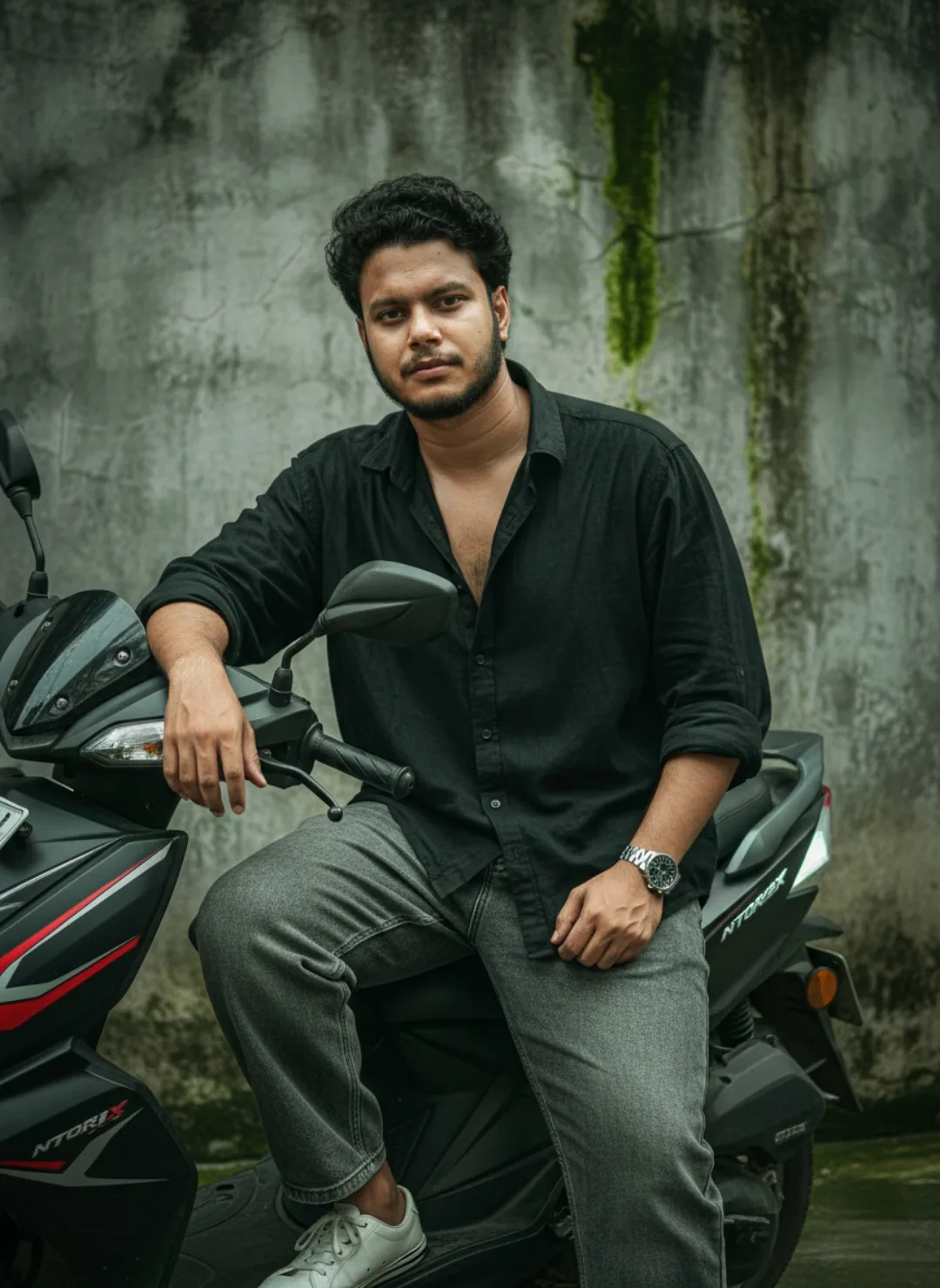 > A realistic, high-detail portrait of a 26-year-old South Asian man with curly dark hair and a well-groomed beard, sitting casually
