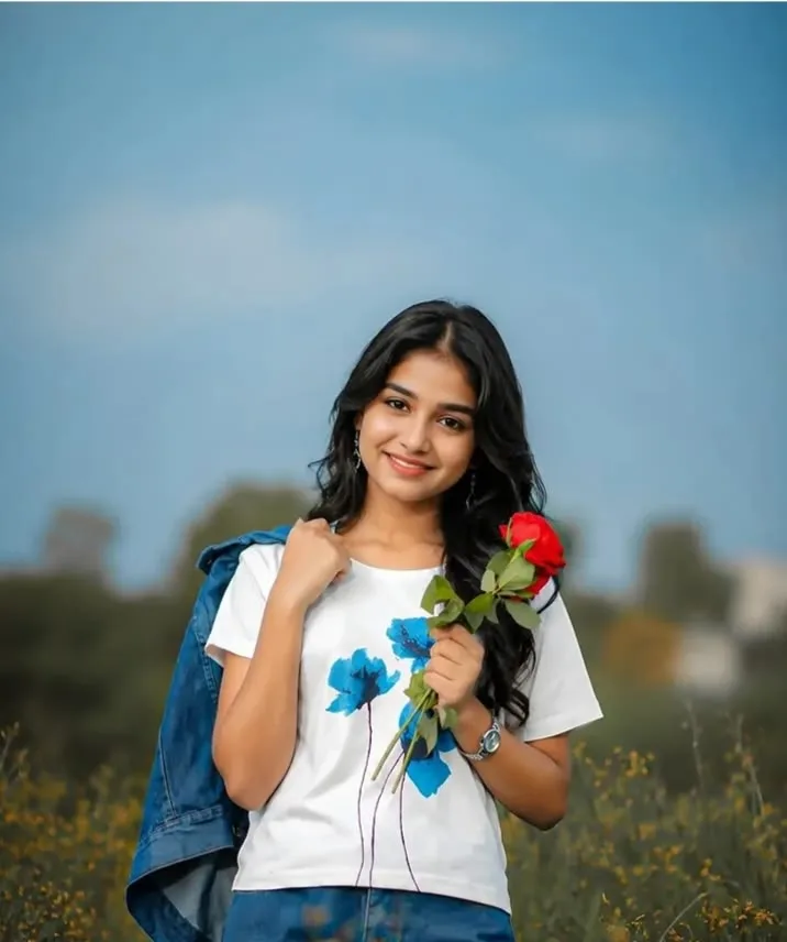 Candid Outdoor Meadow Portrait of Young Indian Woman Holding Red Rose