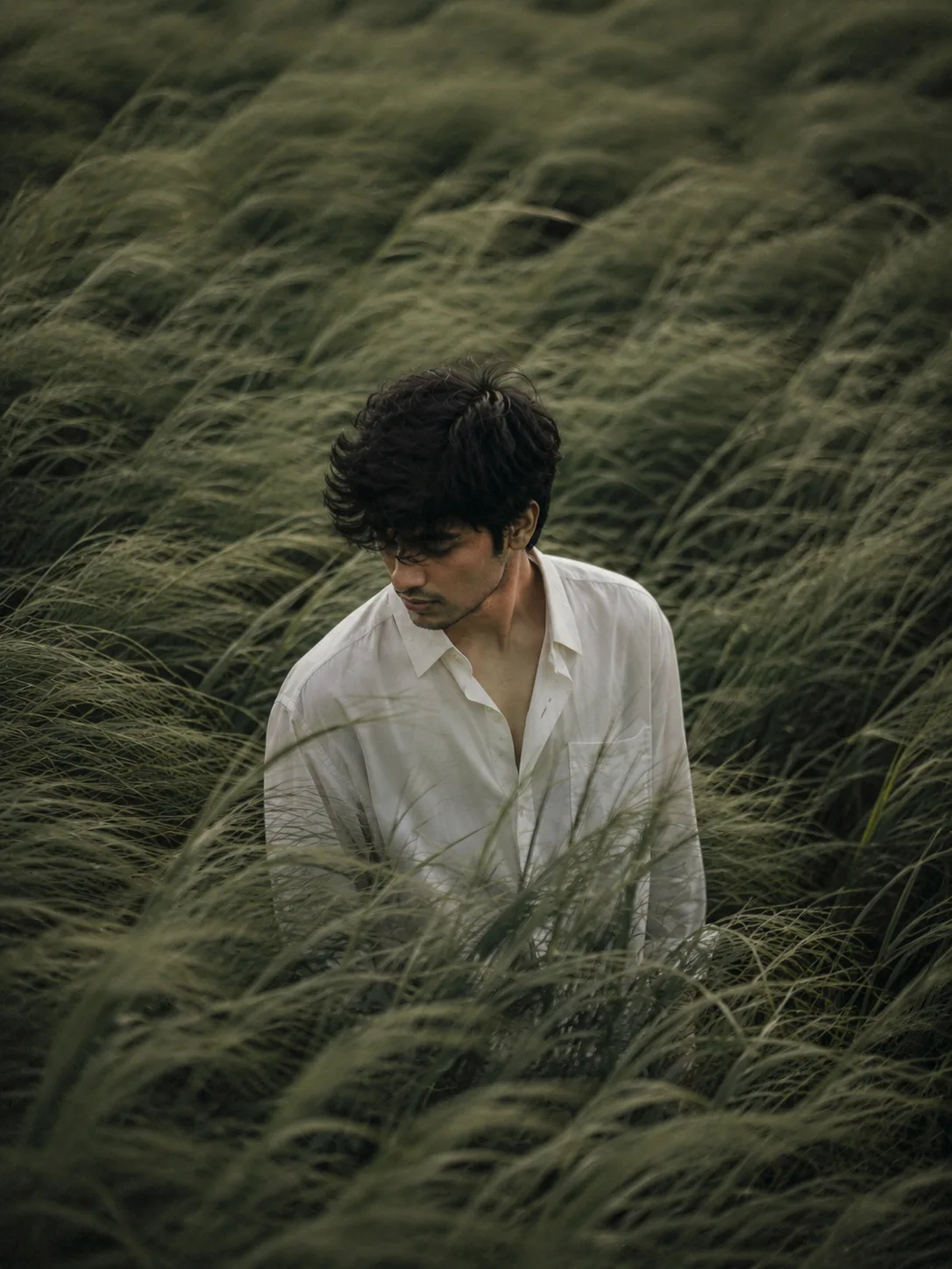 Create a 3:4 cinematic, atmospheric editorial portrait using the attached photo as the exact face and identity reference.