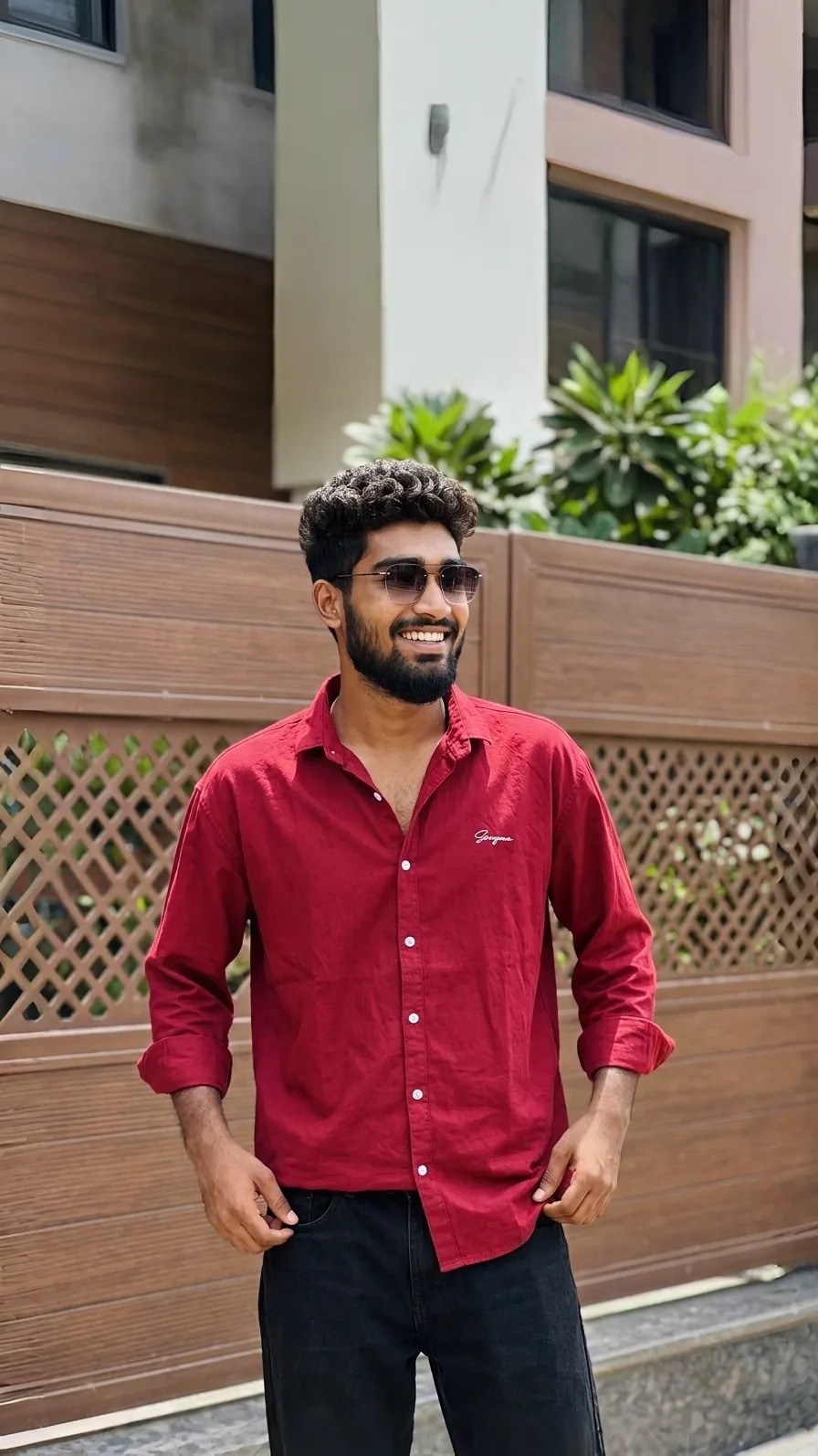 A photorealistic vertical medium shot of the young South Asian man from the reference images, faithfully preserving his recognizable facial