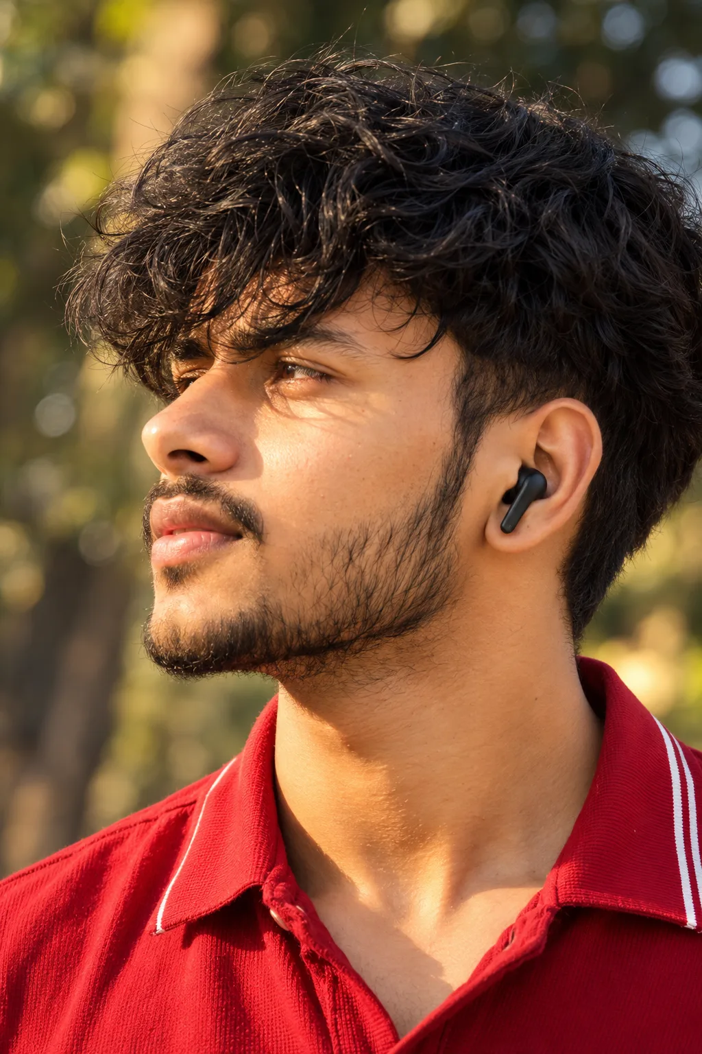 ULTRA-REALISTIC 8K DSLR PHOTOGRAPH, tight vertical close-up side-profile portrait of a young South Asian man outdoors, facing left with his