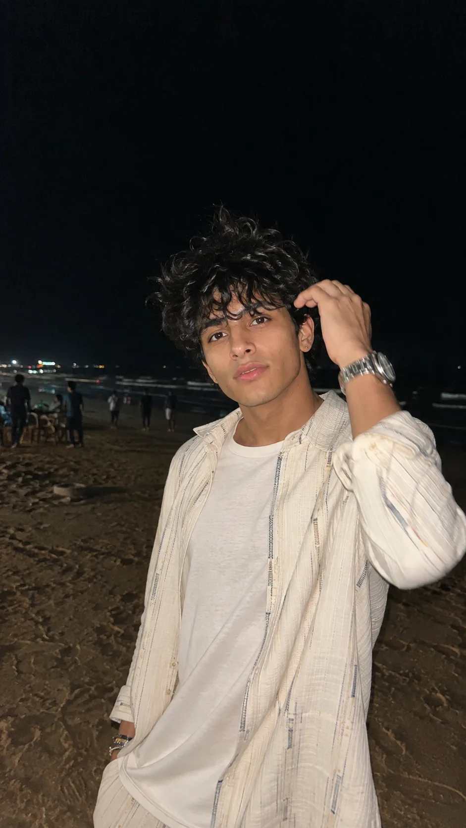 Visual Style: Ultra-photorealistic nighttime lifestyle photography × candid smartphone portrait × contemporary menswear × coastal nightlife