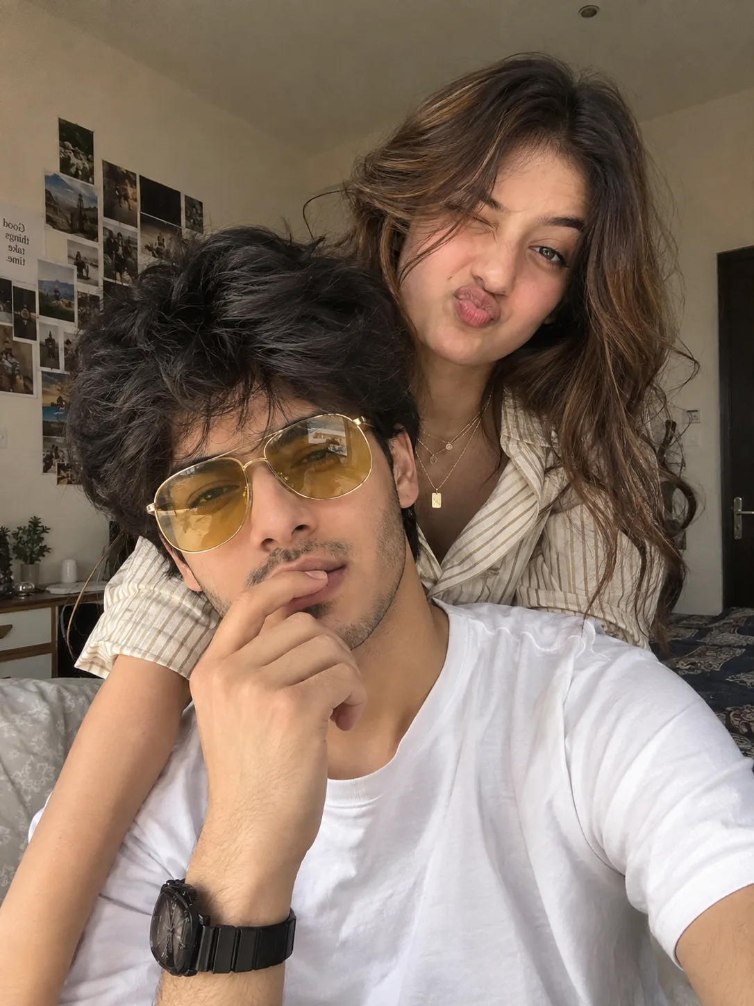 A REALISTIC, HYPER-DETAILED CANDID PHOTOGRAPH OF A PLAYFUL SOUTH ASIAN COUPLE POSING INDOORS.