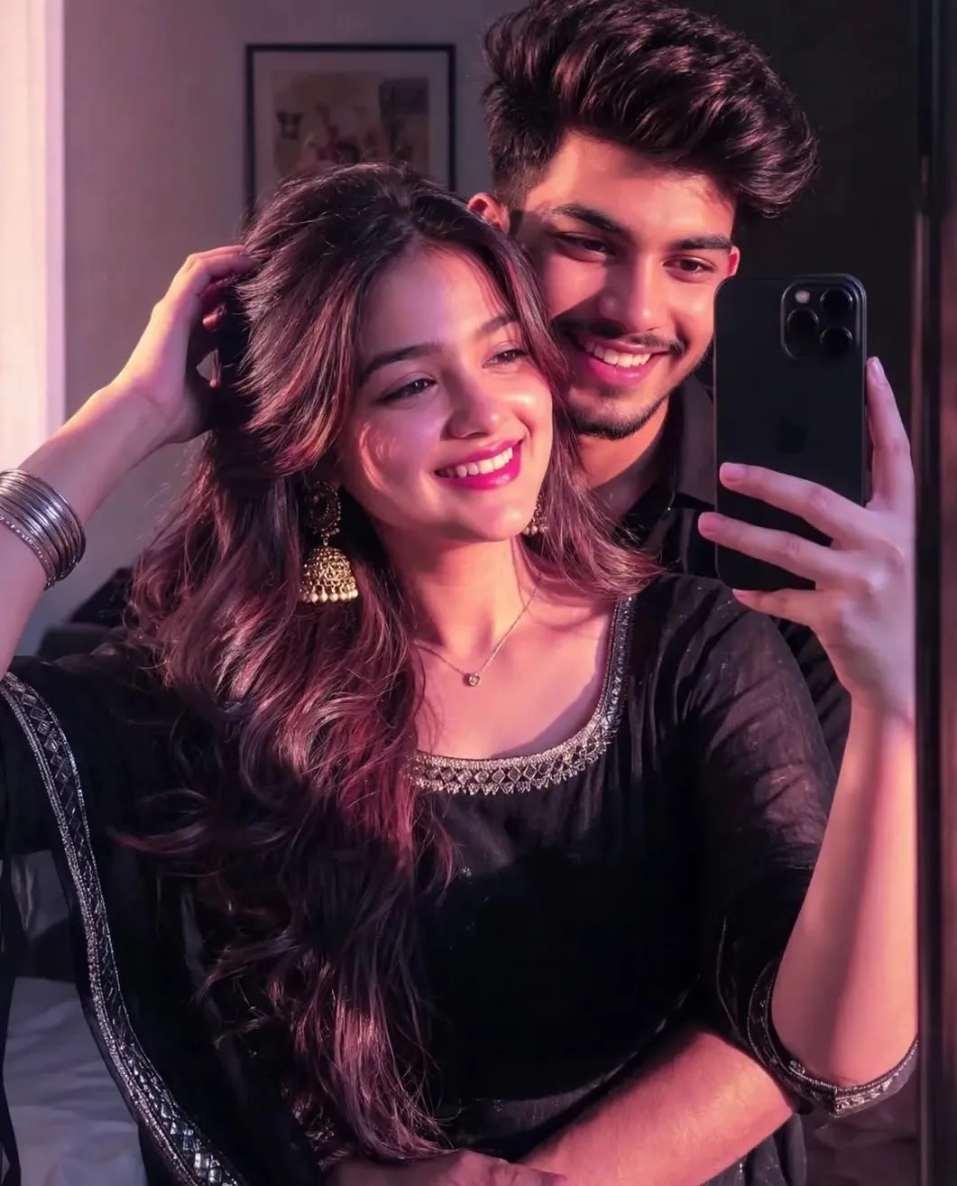 Couple mirror selfie, boy hugging girl from behind, chin near girl's shoulder, both looking in mirror smiling happily.