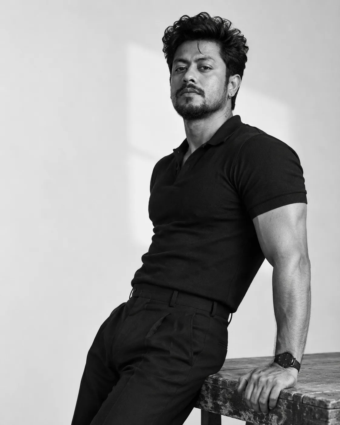 Create an ultra-realistic black-and-white high-fashion editorial portrait of a handsome South Indian man in his late thirties, photographed