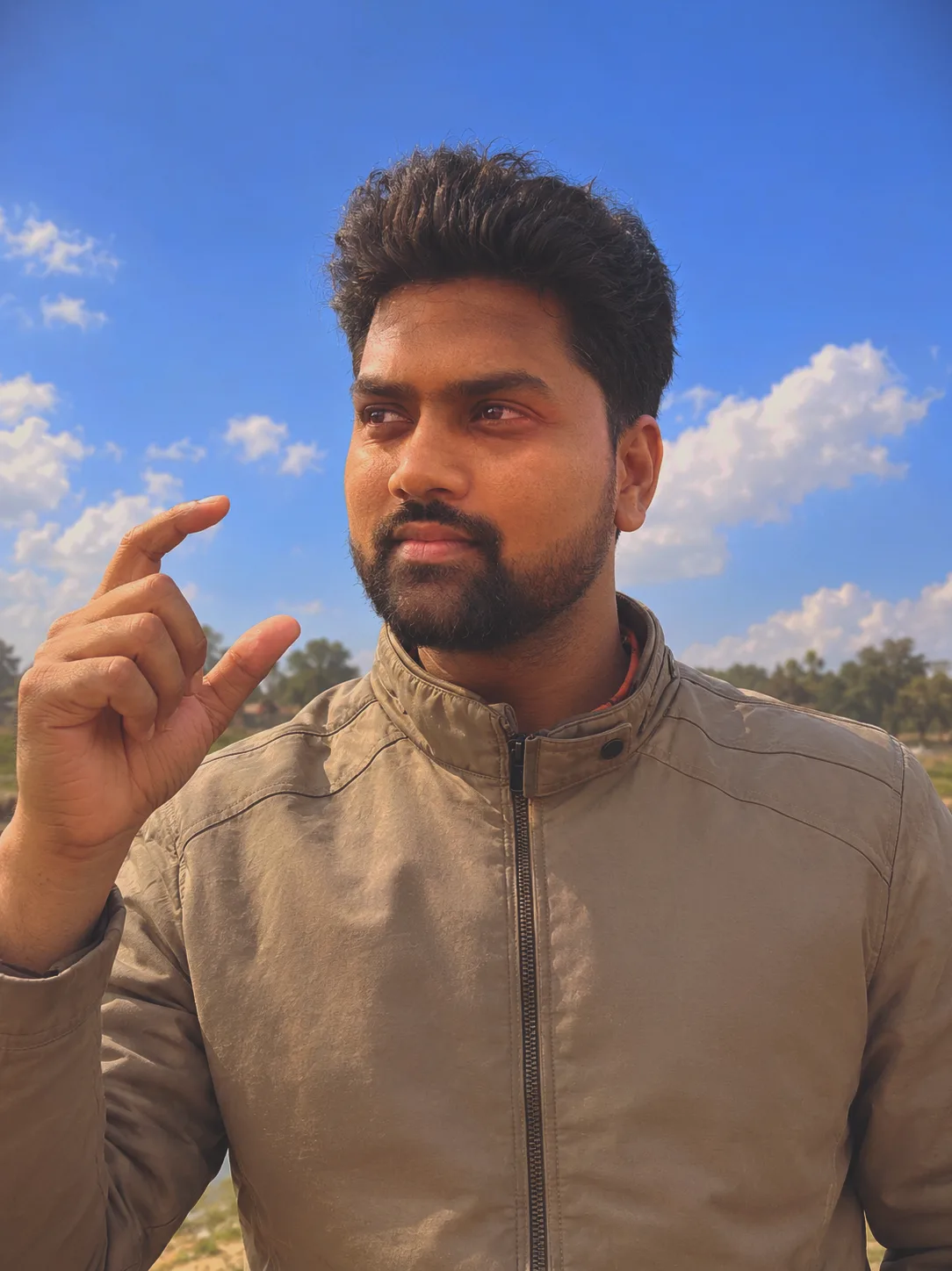 A photorealistic close-up portrait of a young South Asian man with a neat beard and stylish dark hair, wearing a beige zippered