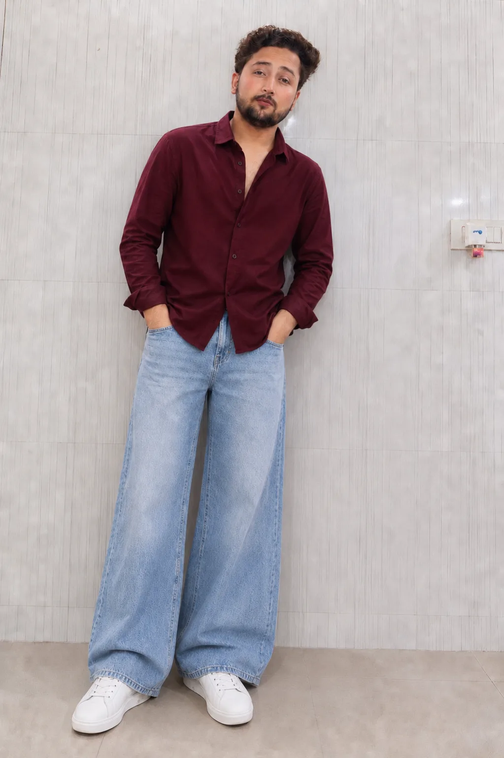 Ultra-realistic full-body fashion portrait of a stylish young South Asian man standing casually indoors against a light grey vertically