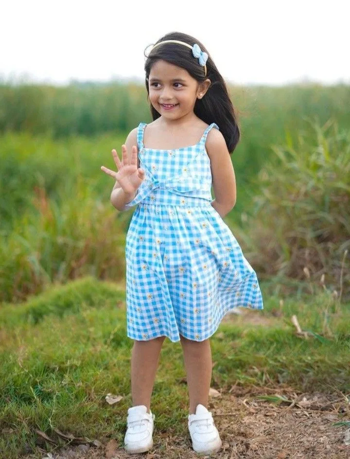 A photorealistic full-body vertical portrait of the young South Asian girl from the reference image, faithfully preserving her exact facial