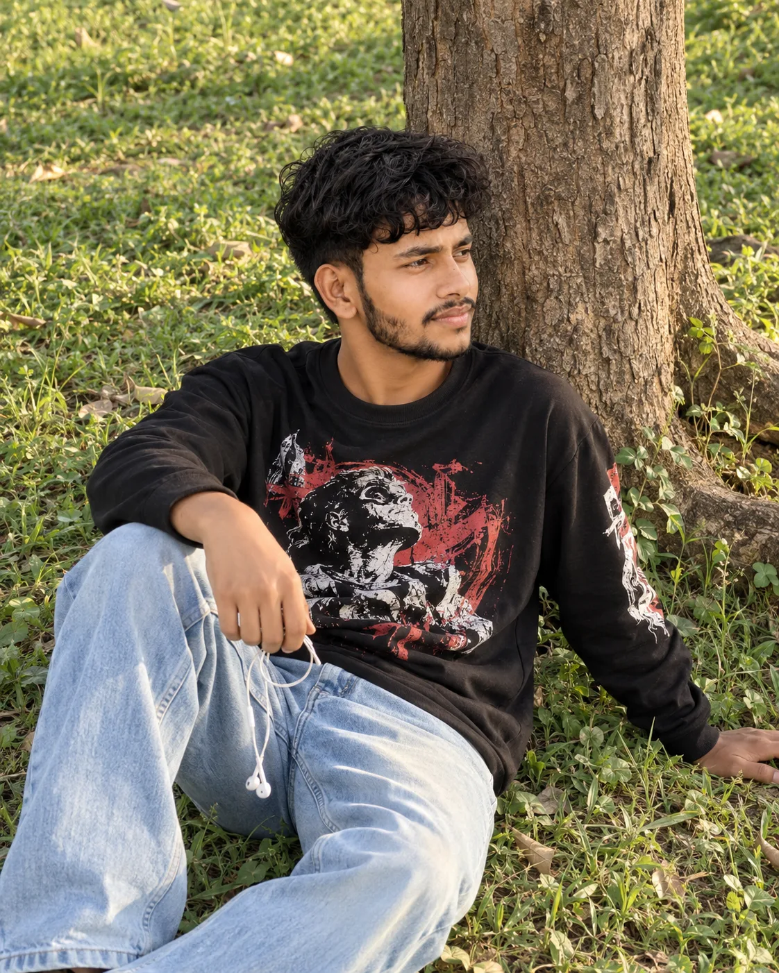 Generation Prompt: Ultra-realistic 8K DSLR photograph of a young South Asian man sitting casually on lush green grass outdoors, leaning his