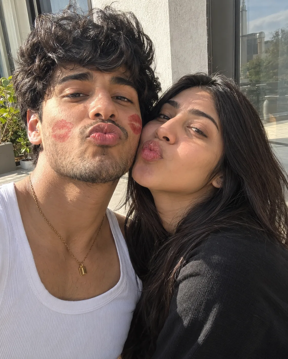 A realistic, close-up selfie of a youn g South Asian couple.