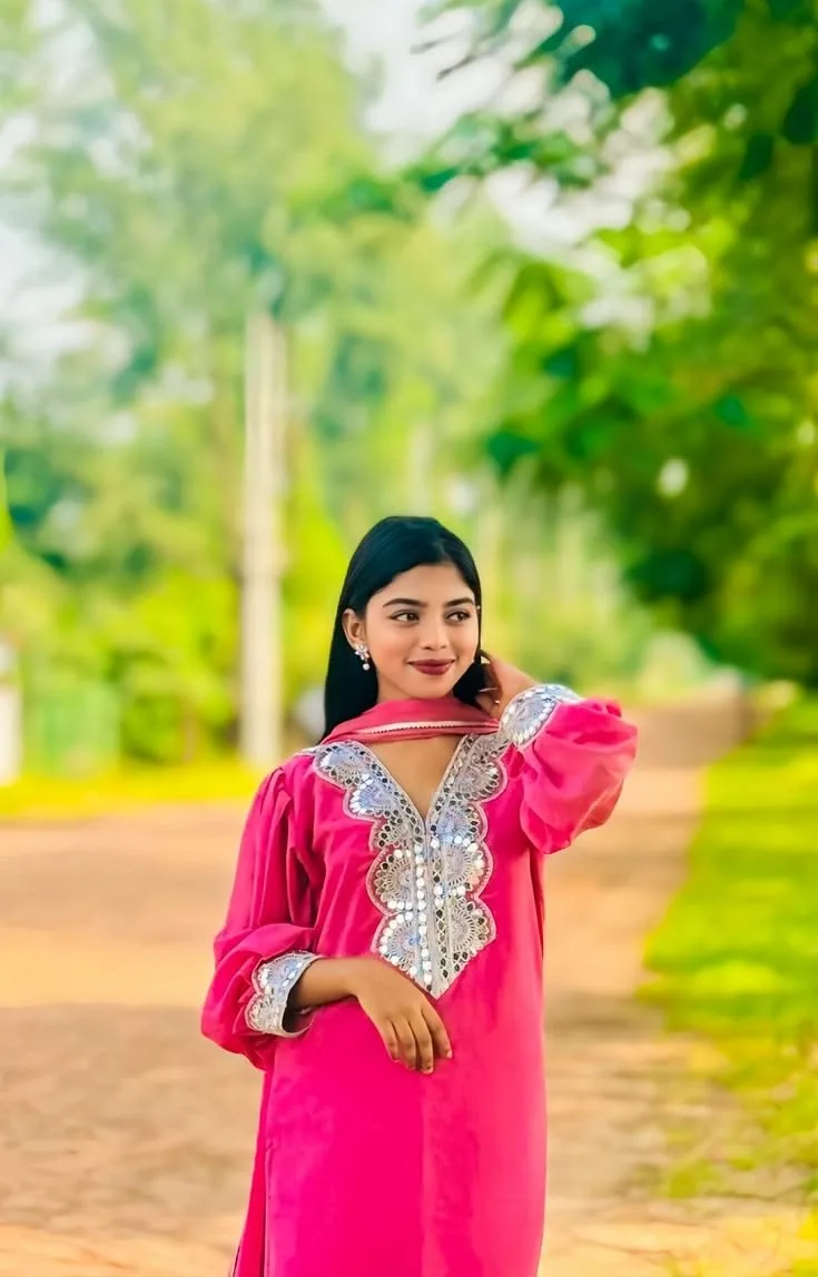 A photorealistic vertical medium shot of the young South Asian woman from the reference image, faithfully preserving her recognizable