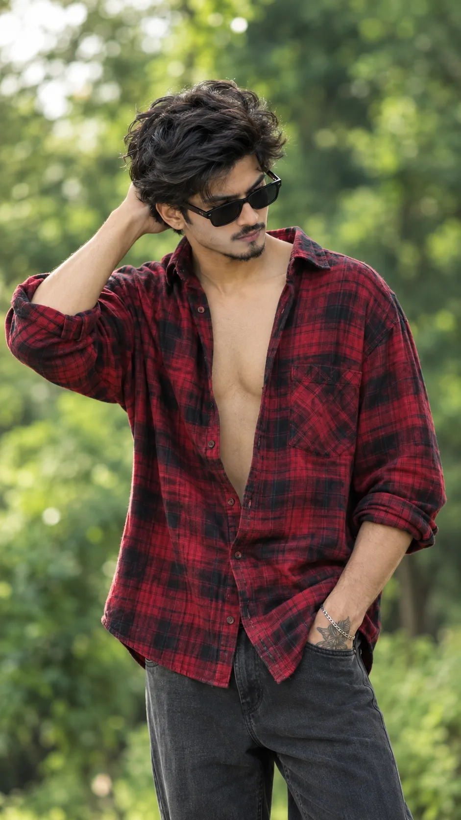 Create a highly photorealistic, cinematic portrait of a stylish young South Asian man (early 20s) standing outdoors in a lush, green