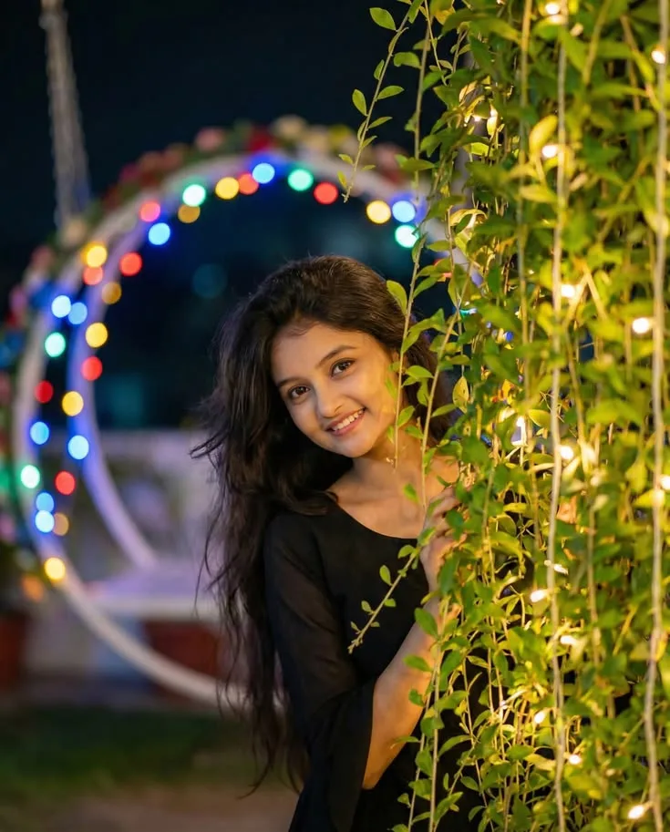 A photorealistic vertical medium shot in exact 3:4 aspect ratio capturing the young South Asian woman from the reference image outdoors at