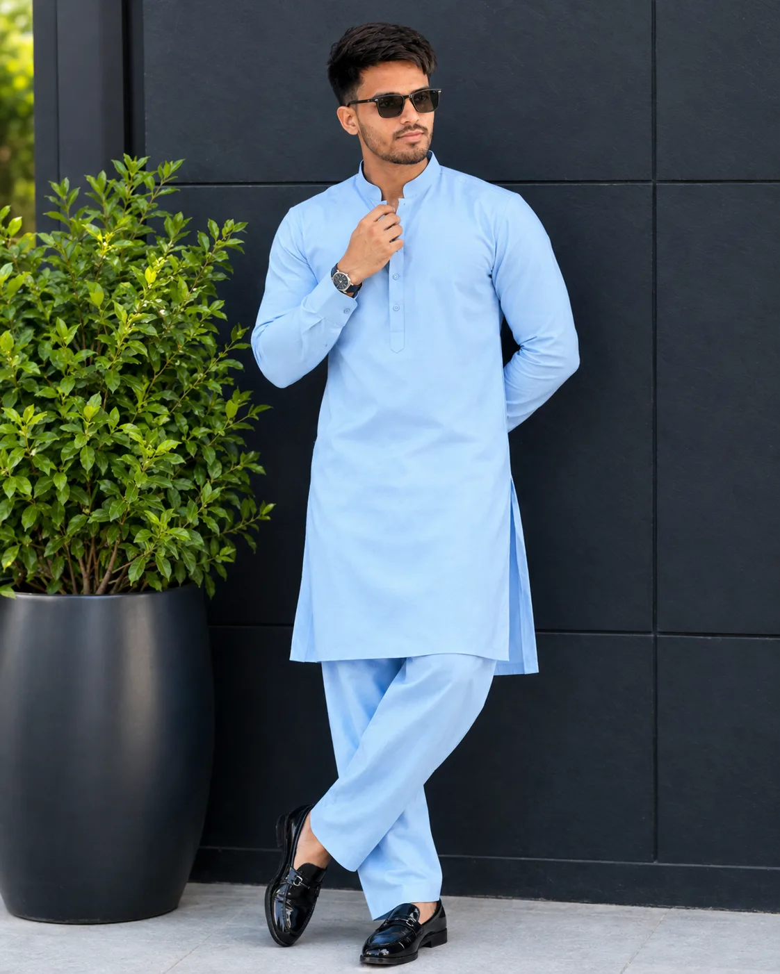 Create a highly realistic full-body fashion portrait of a stylish young South Asian/Indian man standing confidently outdoors in a modern