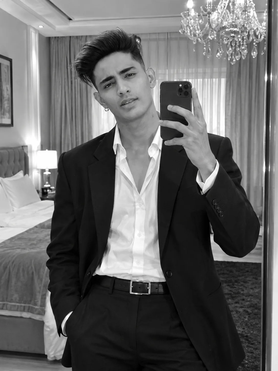 **A mirror selfie of a handsome young man with messy dark hair, taking a photo with his modern smartphone.