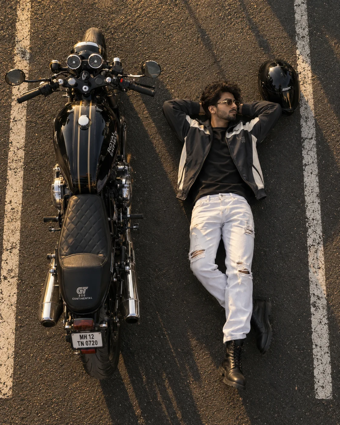 A slim-fit young man. Ultra-realistic cinematic top-down drone photograph of a stylish young man lying on a dark asphalt parking lot beside