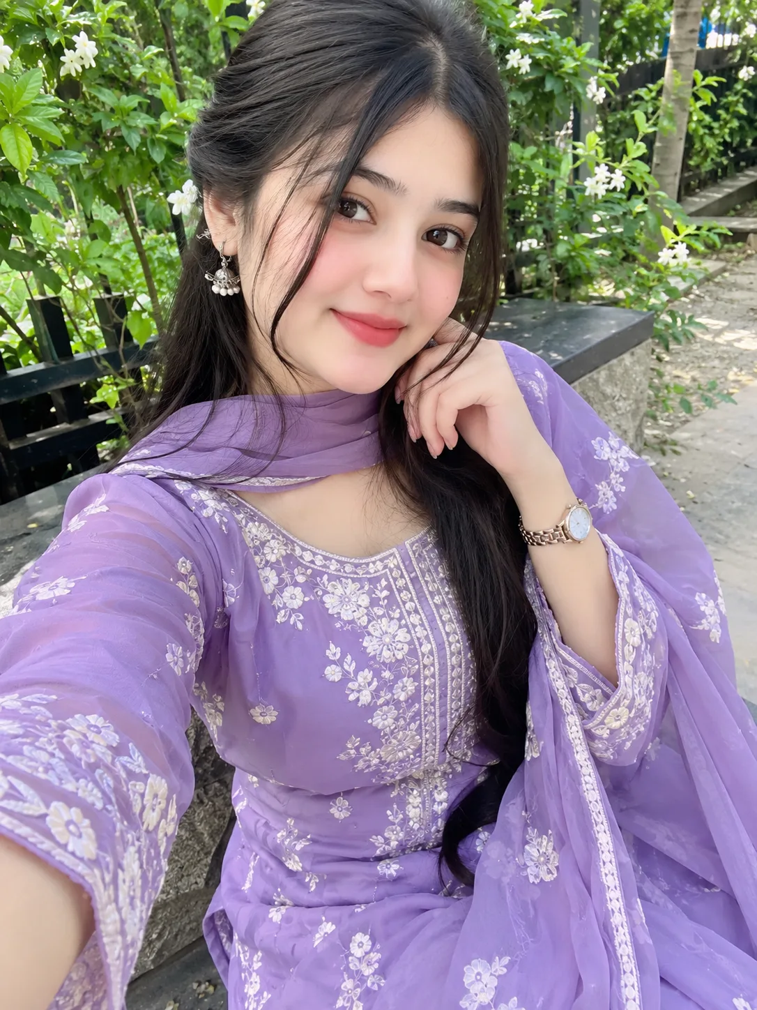 A beautiful young South Asian woman wearing a stunning lavender embroidered traditional dress with a matching dupatta, elegant jewelry, and