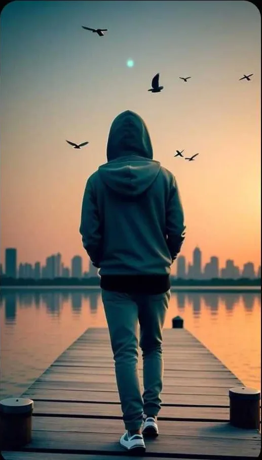 Cinematic back view of a person in a hoodie walking on a wooden dock over a calm lake, birds flying in the sky, distant skyline, soft