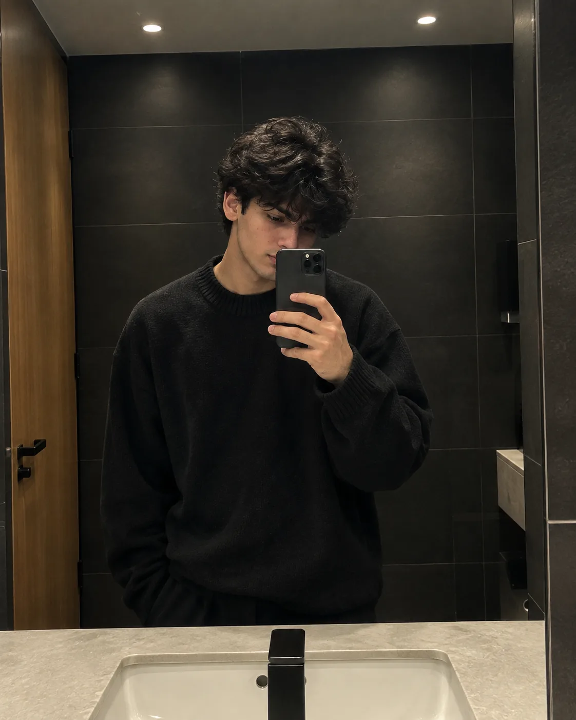Create an ultra-realistic premium mirror-selfie portrait of a young male standing inside a sophisticated contemporary bathroom.