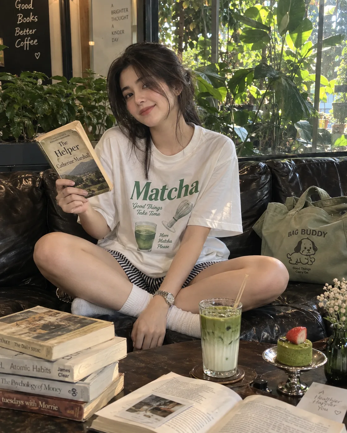 A candid, natural indoor photograph of the young Asian woman, captured on a relaxed afternoon in a lush, plant-filled cafe while wearing