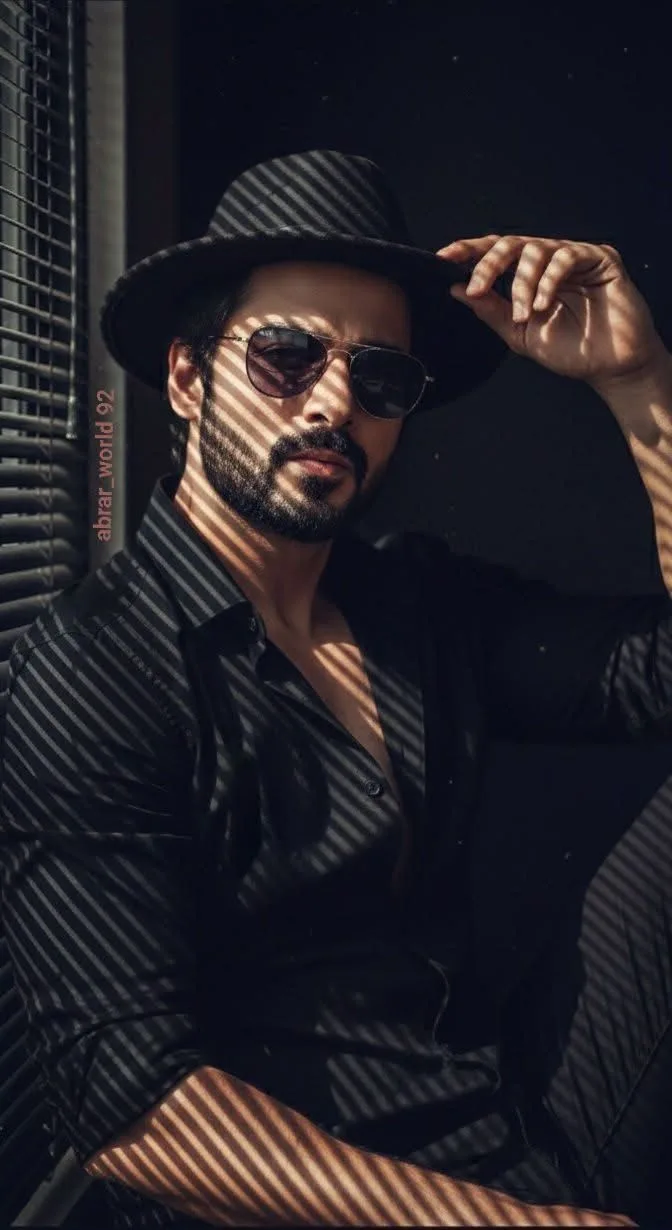 A striking low-key medium close-up portrait of a handsome man with a thick, well-groomed beard and mustache, looking intensely into the