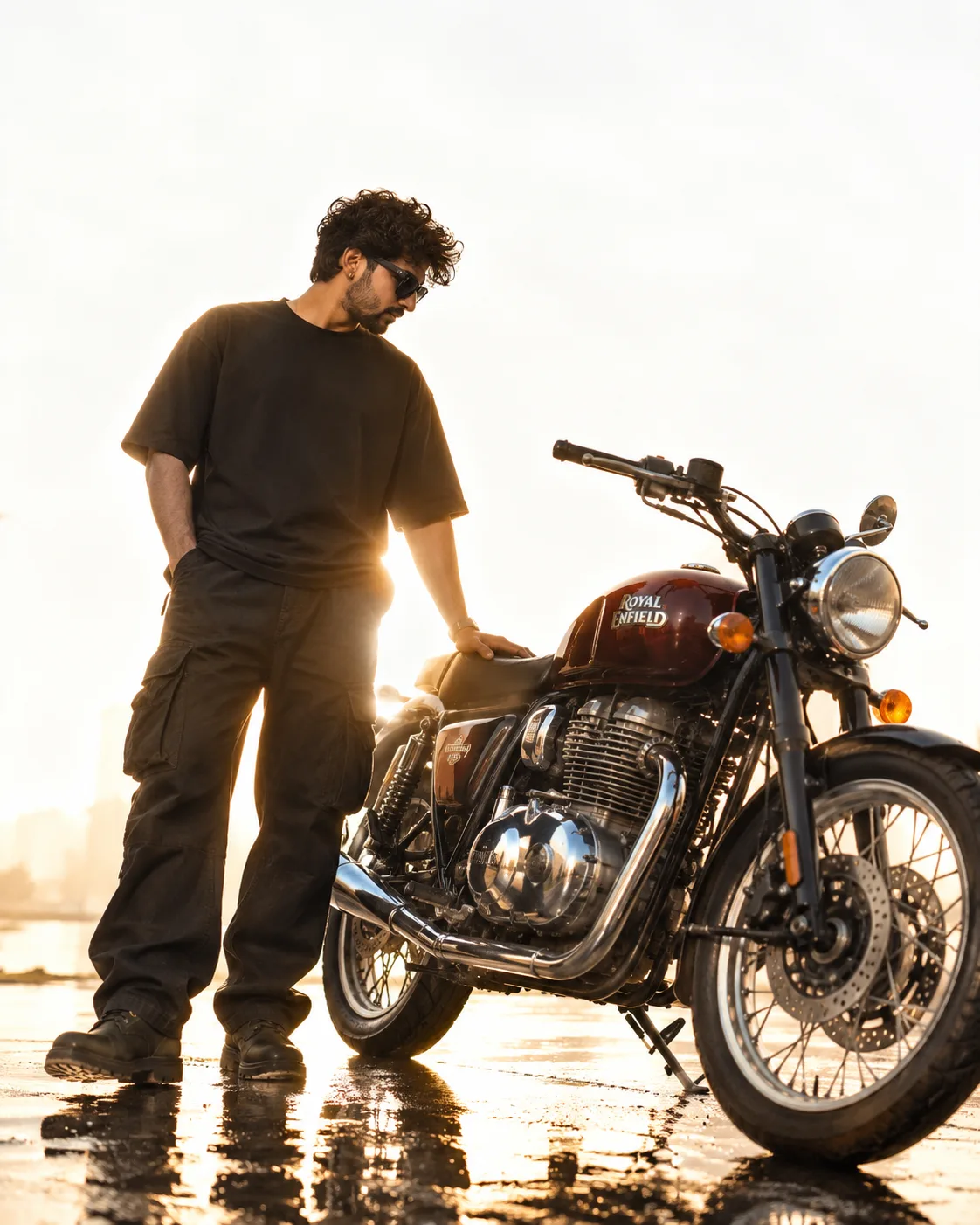 A stylish young man with curly black hair, moustache and beard, wearing black sunglasses, a loose black t-shirt, dark cargo pants and