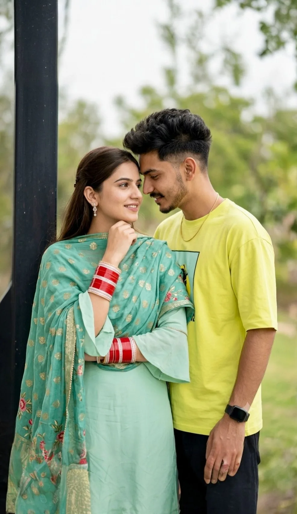 A photorealistic vertical medium shot capturing a candid outdoor moment of the young South Asian couple from the reference image,
