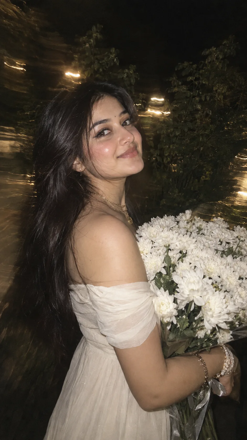 PHOTOREALISTIC 9:16 NIGHT TIME PORTRAIT OF A YOUNG SOUTH ASIAN WOMAN WITH VOLUMINOUS GLOSSY DARK HAIR, SOFT GLAM EYE MAKEUP, SHARP