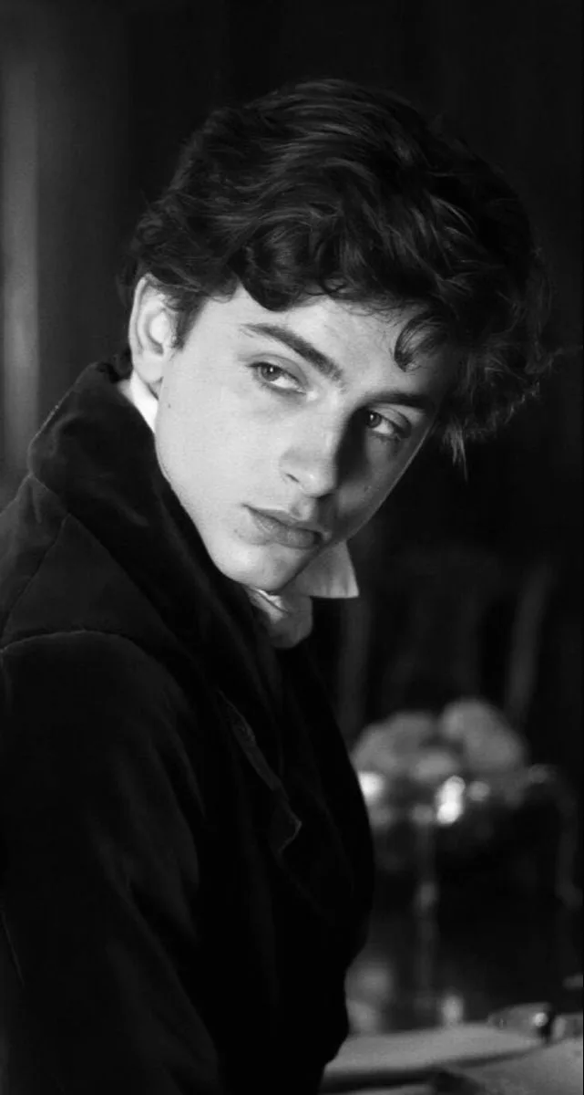 A classic black and white 35mm film photograph portrait of a young 19th-century nobleman looking over his shoulder.